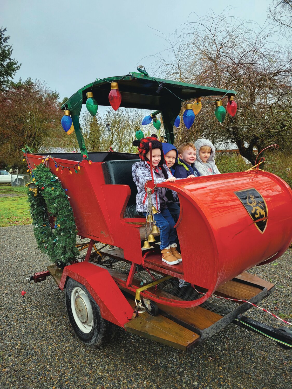 Kids sit in Harry Miller's Santa sleigh, part of his gig as the Cougar Mountain Santa.