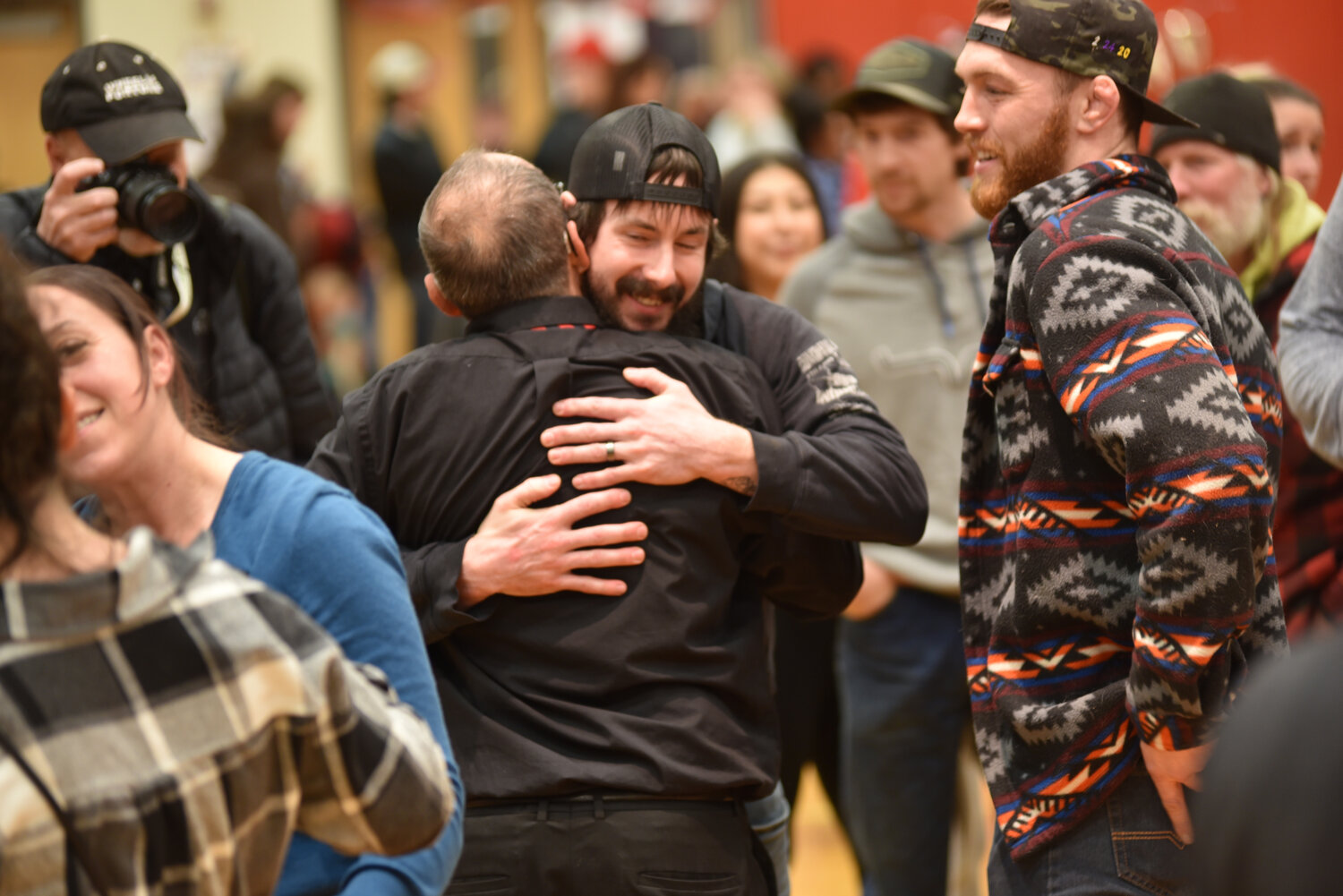Yelm's head wrestling coach Gaylord Strand embraces a former athlete on Jan. 23 after the coach's final home dual as a Tornado.