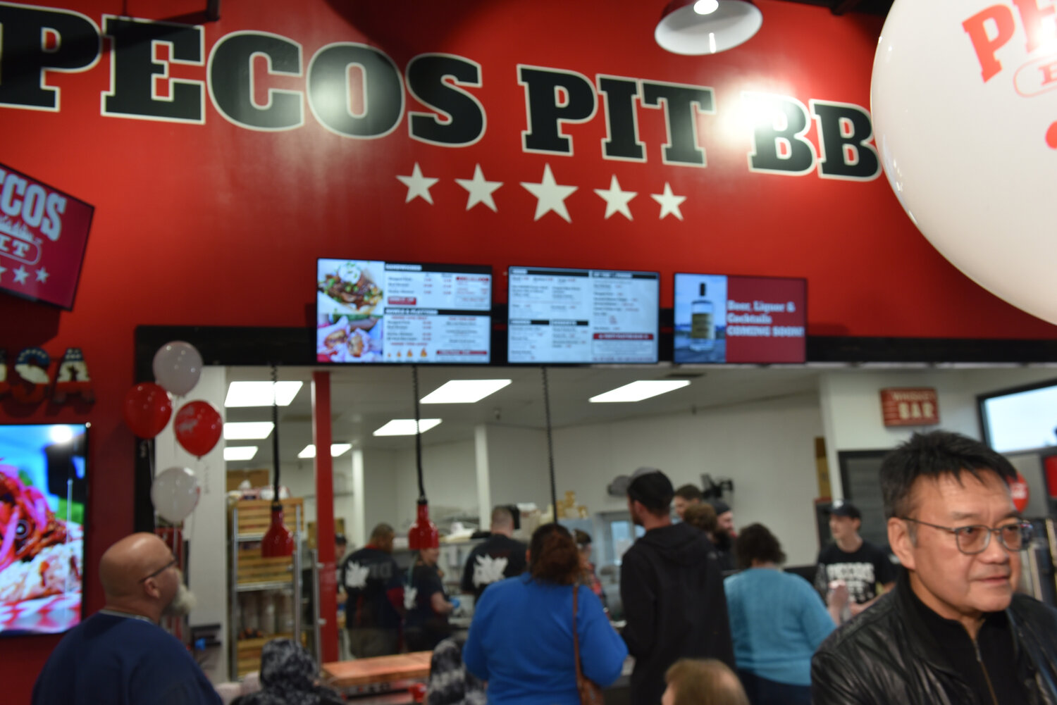 Customers at Pecos Pit Bar-B-Que order food on Friday, Jan. 26 after the restauraunt's grand opening celebration.