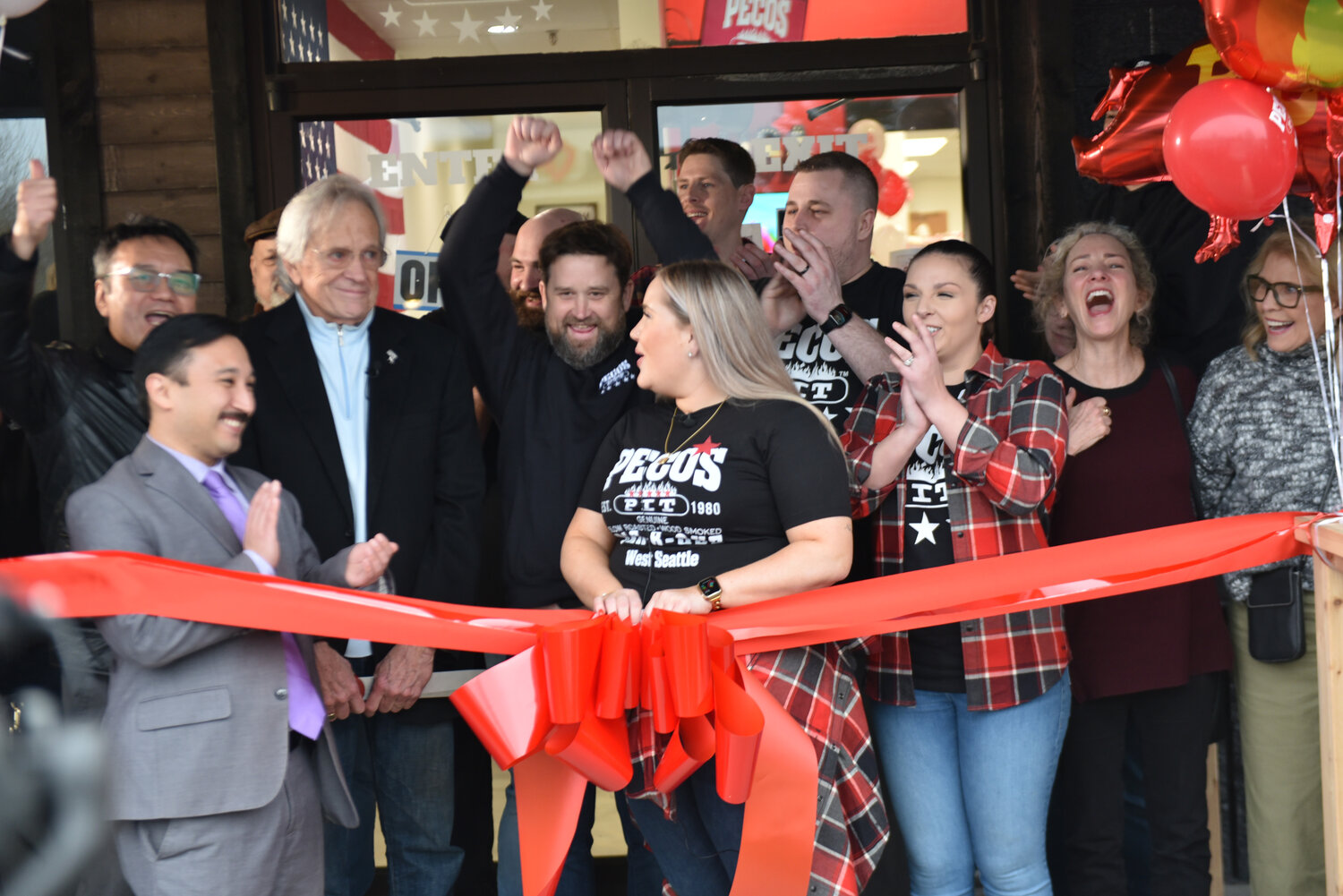 Attendants at Pecos Pit Bar-B-Que's grand opening in Yelm cheer and celebrate after opening remarks from owner Gerry Kingen on Friday, Jan. 26.
