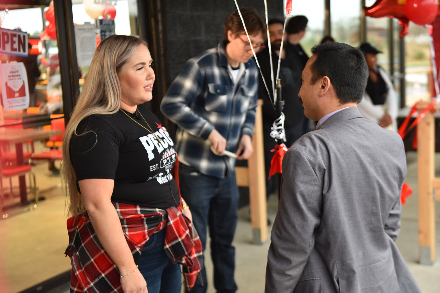 Yelm's mayor Joe DePinto, right, talks with Brie Noble, Pecos Pit Bar-B-Que's director of marketing and public relations, prior to the resturuant's grand opening on Friday, Jan. 26.