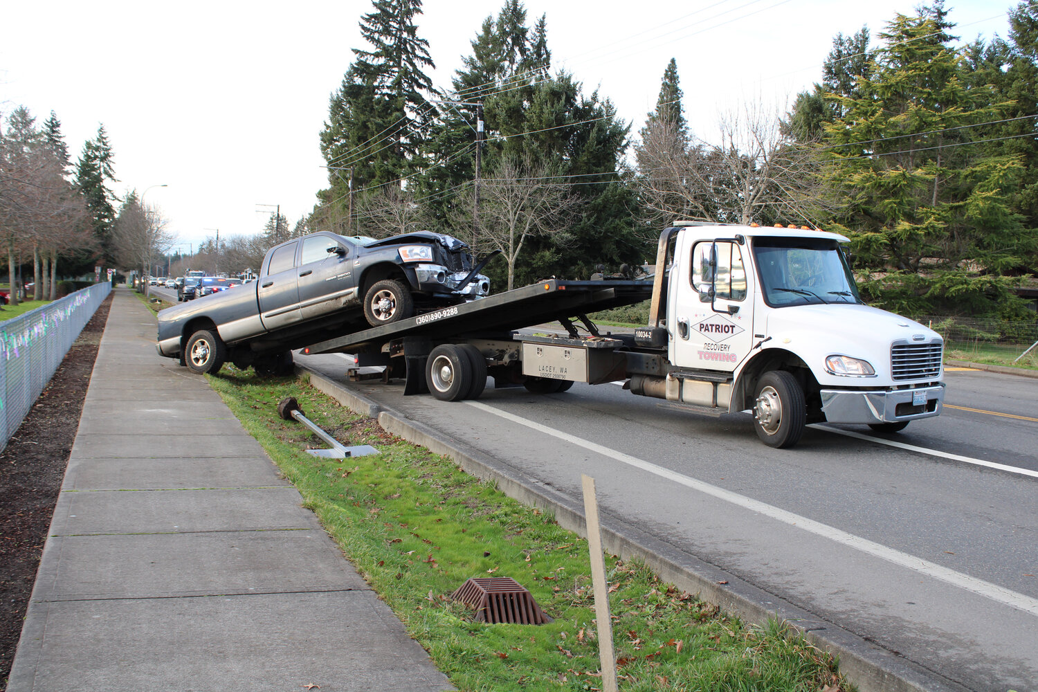 A tow truck from Patriot Recovery Towing lifts the damaged Dodge Ram from the sidewalk in front of Yelm High School on Jan. 30.