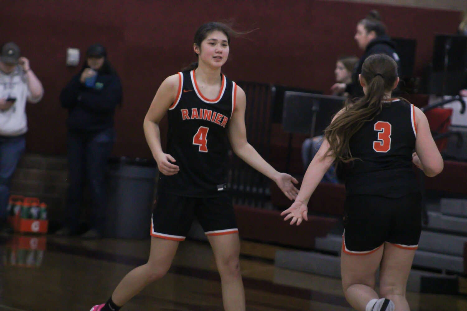 Angelica Askey (4) and Brooklynn Swenson (3) high five each other after scoring a basket against Raymond-South Bend on Feb. 6.